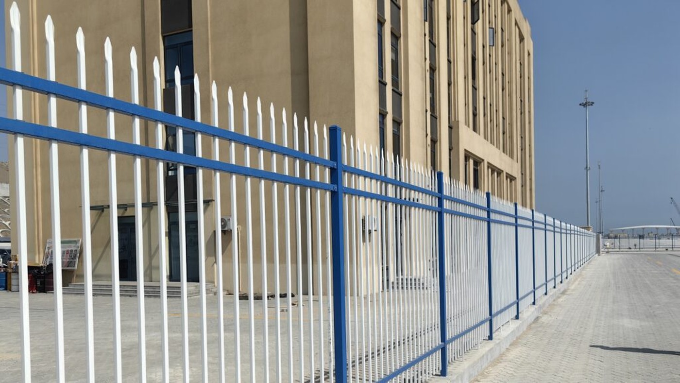 Blue and white steel bar fence around office area
