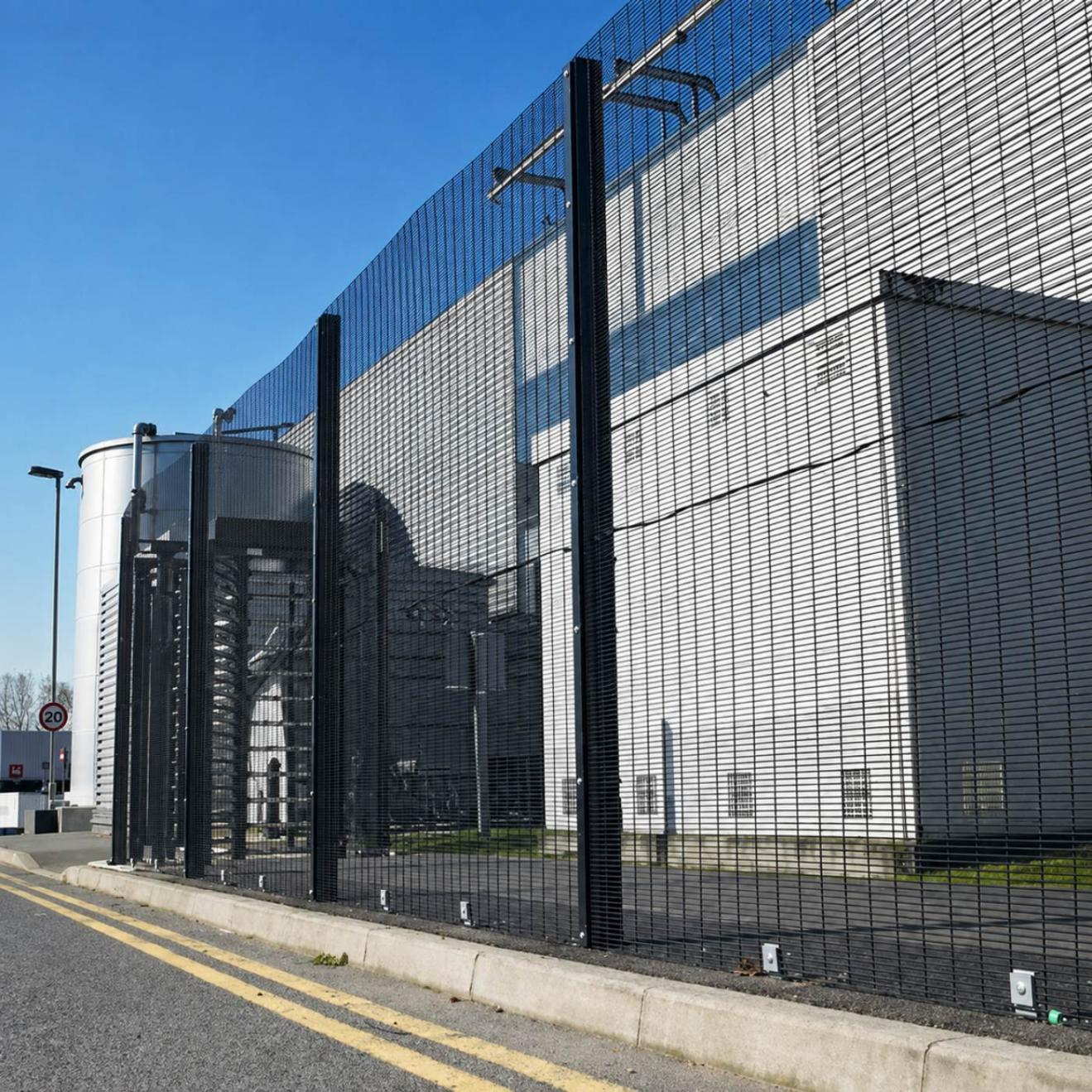 Industrial perimeter fence installed on a continuous foundation with aligned posts and panels