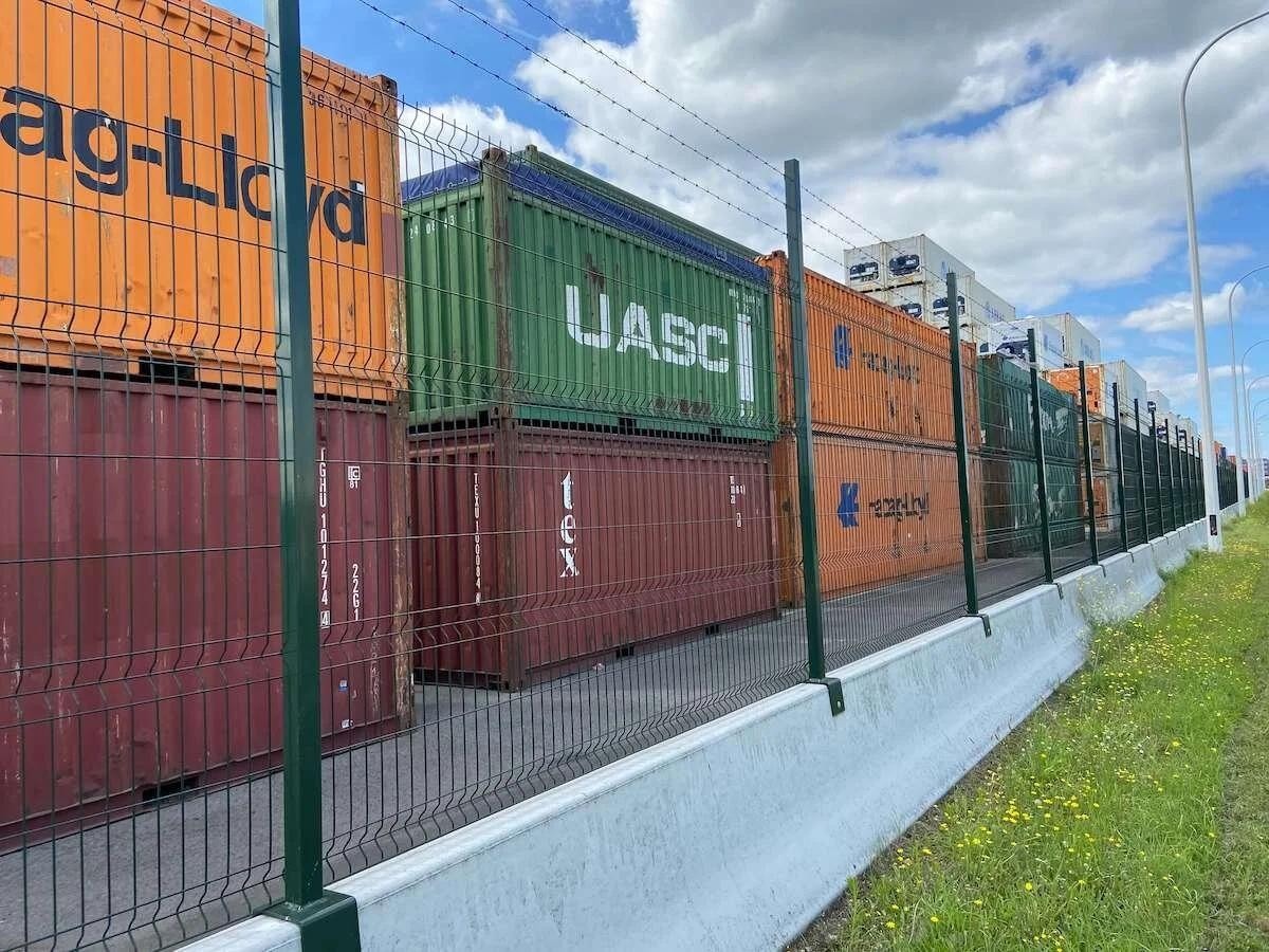 Long perimeter fence beside a logistics container yard
