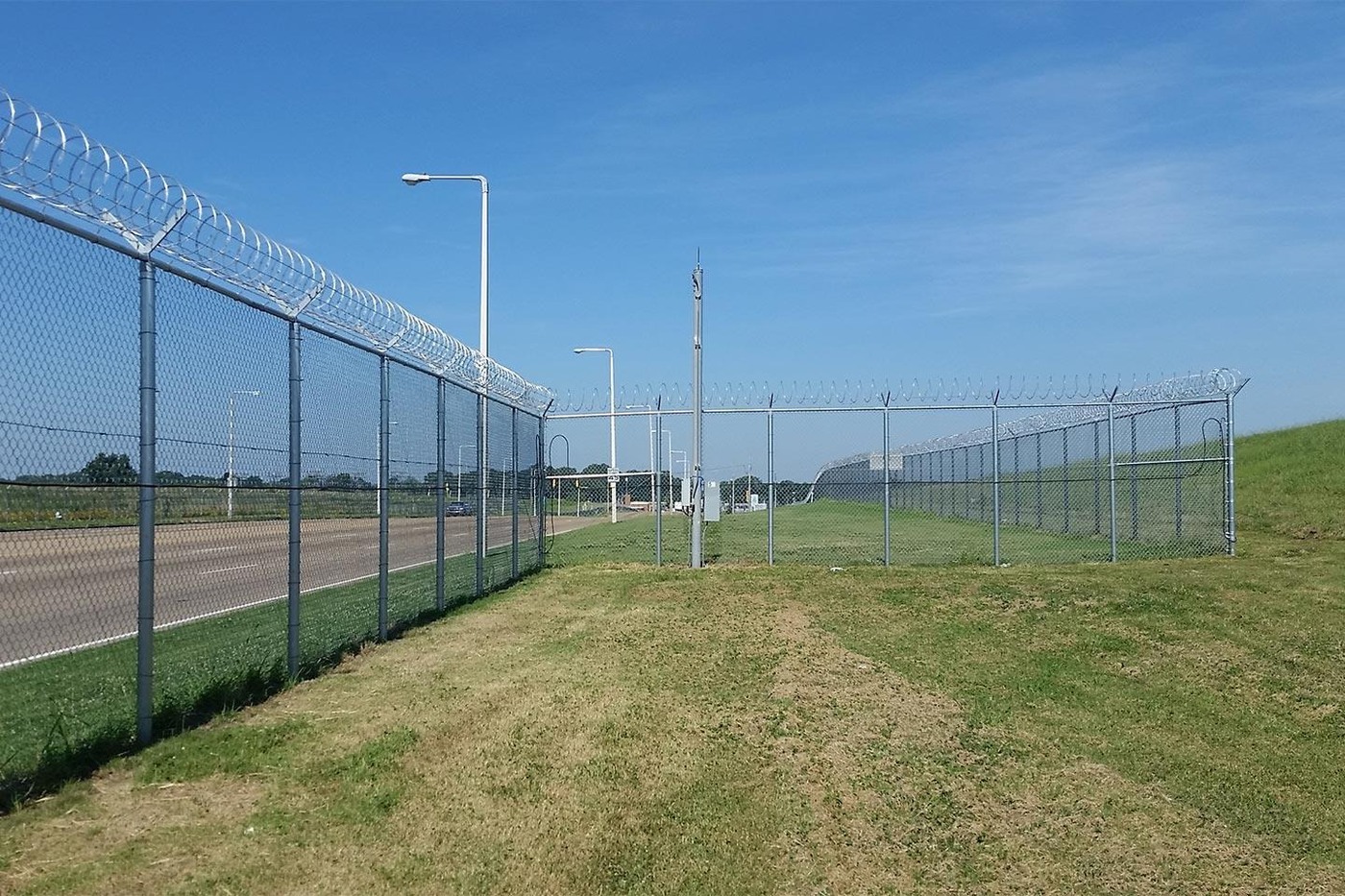 Chain-link airport perimeter fence with razor wire top protection