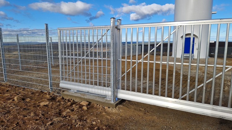 Puerta de columpio de metal integrada con una cerca del perímetro