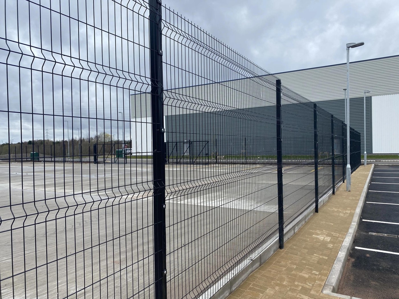 Continuous mesh fence along an office perimeter road